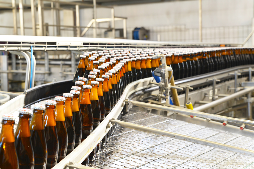 Fliessband mit Bierflaschen in einer Brauerei – automatisierte Industrieanlage // bottles in a brewery
