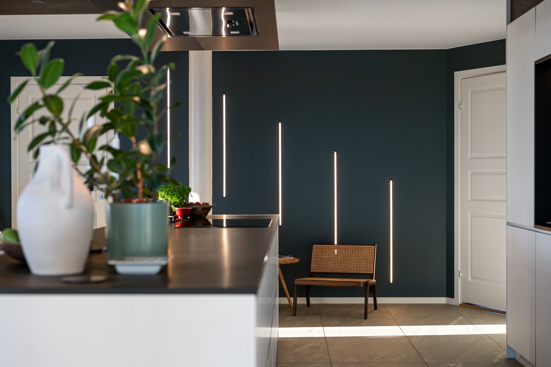 Modern beleuchtete Küche und Essbereich mit wandintegrierten Lichtlinien als Beispiel für professionelle Lichtplanung
