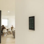 Basalte Ellie Touchpanel an einer hellen Wand zur Steuerung von Licht, Beschattung und Smart-Home-Funktionen.