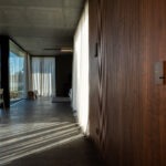 Basalte Fibonacci und Touch-Panel an hochwertiger Holzwand in offenem Wohnkonzept – FWZ Elektrotechnik Referenz Villa am Main.