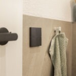 Basalte Sentido Taster in dunkler Ausführung, dezent in eine geflieste Wand im Bad integriert.