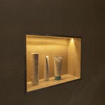 Beleuchtete Duschnische mit integrierter LED-Beleuchtung und stilvoll platzierter Pflegeprodukte.