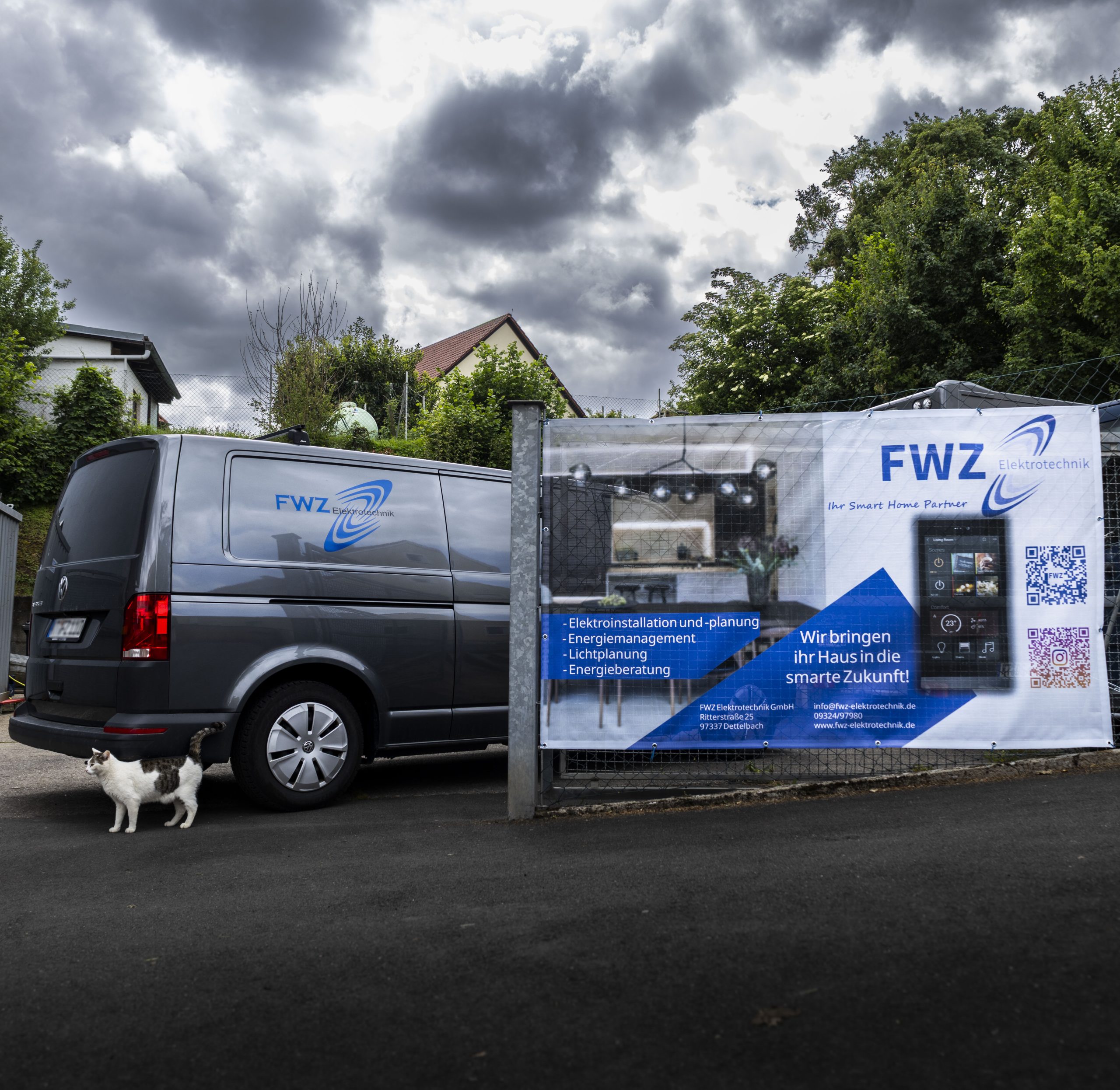 Werbebanner von FWZ Elektrotechnik mit Firmenbus im Hof – Elektroinstallationen und Smart Home