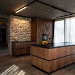 Exklusive Küchenbeleuchtung mit modernem Schienensystem und Akzentlicht an der Steinwand – FWZ Elektrotechnik Referenz Villa am Main.