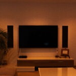 TV-Wand mit integrierten Lautsprechern und warmer Lichtszene für Wohnraumkino und Musikgenuss.