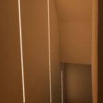 Treppenhaus mit warmweißen LED-Lichtlinien als stimmungsvolle Akzent- und Orientierungsbeleuchtung.